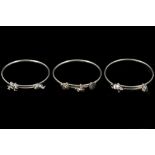 Three hallmarked silver bangles, with fixed charms