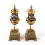 A pair of 20th Century champleve decoration urn garniatures, gilded lids adorning marble cylindrical