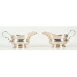 A pair of silver sauce / gravy boats, fluted rim, loop handle, oval foot, maker's marks for H