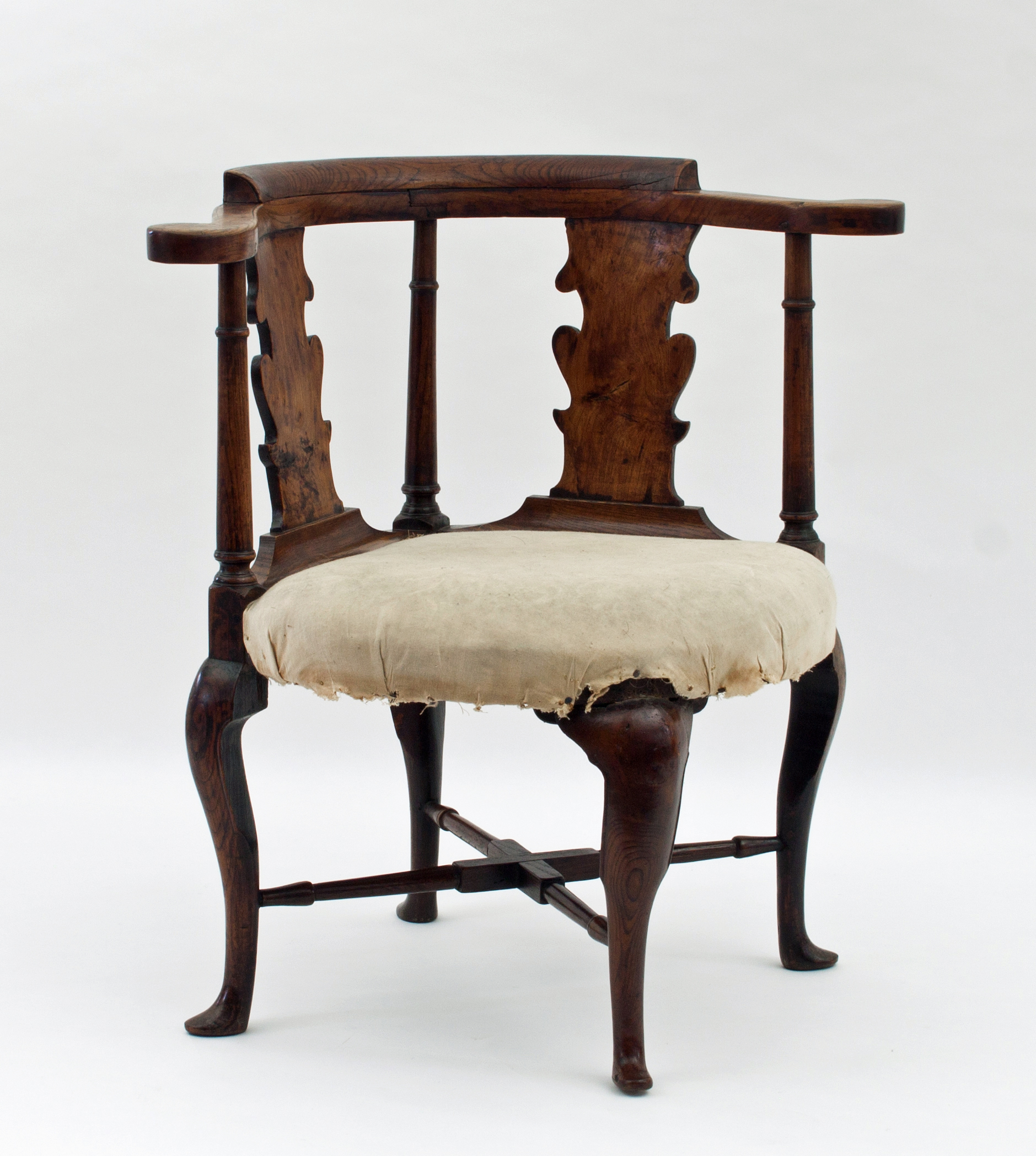 A George I elm desk chair with bowed top rail and vase shaped splats, the stuff-over seat on