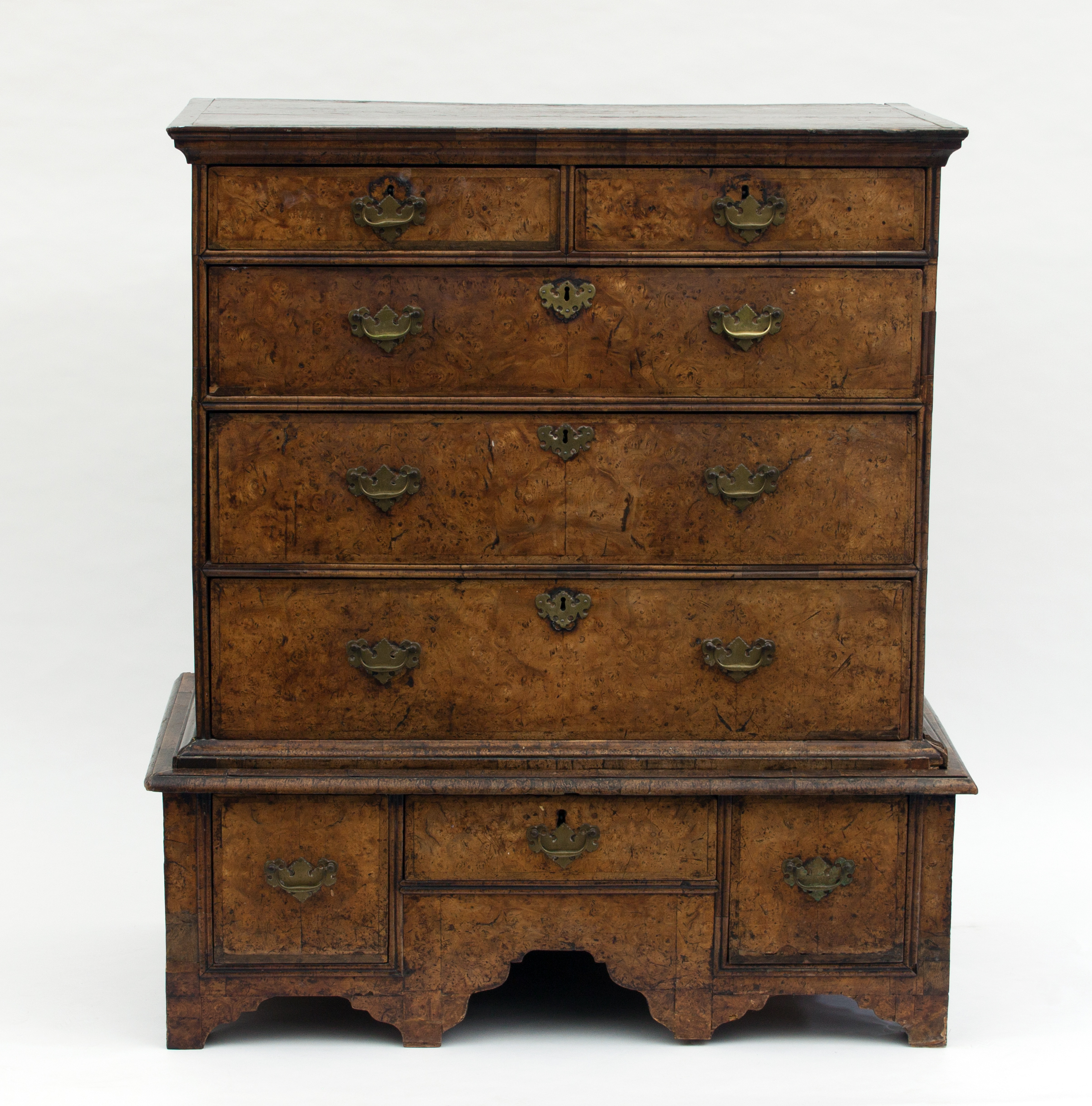 A Queen Anne walnut chest on stand, circa 1710, the chest with two short and three long drawers on a