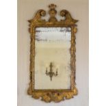 A George I carved gilt gesso wall mirror, the frame with swan neck pediment and cartouche finial, to