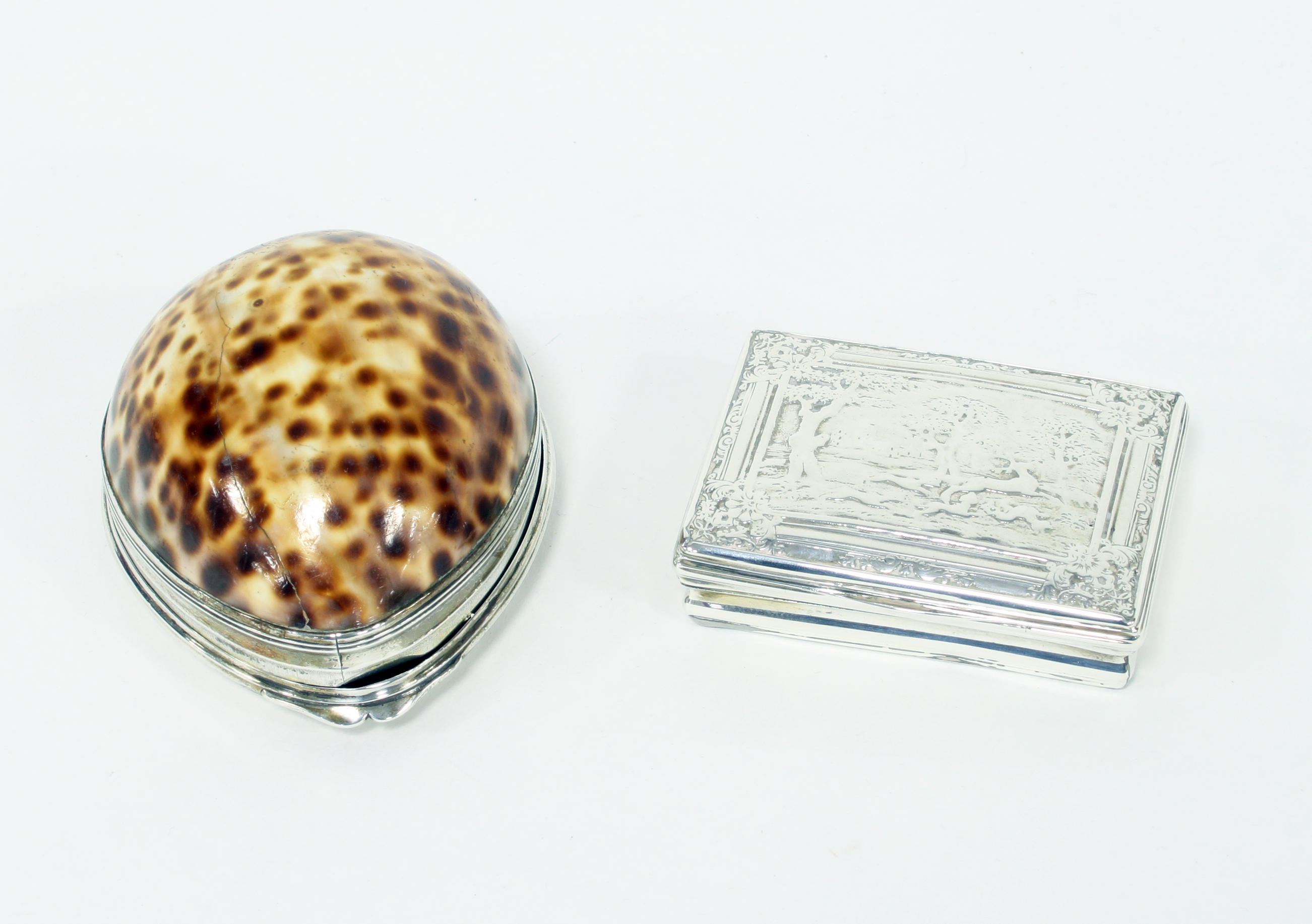 A Georgian cowrie shell box with white metal mounts, the cover crested, 9cm long and a white metal