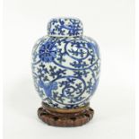 A Chinese blue and white jar and cover, decorated in underglaze blue with scrolling foliage, on a