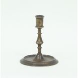 A 17th Century style brass candlestick, with baluster stem on a circular foot, 16.5cm high