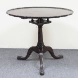 A George II style mahogany tripod table, the piecrust top on bird cage topped column with claw and