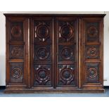 A French/North Italian carved walnut standing cupboard, 17th Century with later elements, with