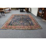 A Turkish carpet, circa 1900, trees and leaves on an indigo ground with guard stripes, 320cm x 250cm