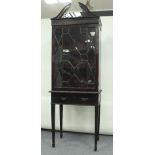 An Edwardian Chippendale style mahogany display cabinet on stand, with swan neck pediment above an