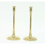 A pair of 18th Century brass coffee house candlesticks, with tall slender stem on a circular foot,