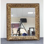 A carved gilt wood framed mirror, the bevelled glass 85cm x 71cm Condition Report: Early 20th