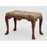 A George I 18th Century walnut stool, the needlework seat on shaped rails and cabriole legs, with