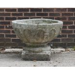 An Irish reconstituted stone bird bath with arch gothic panels to the sides on a circular base,