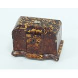 An early 19th Century tortoiseshell tea caddy, of breakfront form, enclosing two lidded
