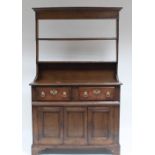 An oak dresser fitted two short drawers with cupboards under enclosed by a pair of panel doors