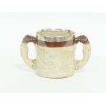 A 19th Century stoneware loving cup with greyhound handles, decorated four scenes in relief, the