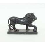 An iron door-stop modelled as a standing lion resting his paw on a ball, 23.