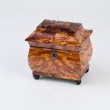 An early 19th Century tortoiseshell tea caddy with pagoda top on ball feet,