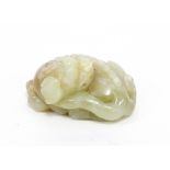 A celadon jade carving of a sleeping lion, 6.