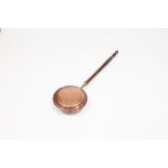 A Victorian copper warming pan with turned wooden handle