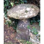 A staddle stone with circular top and tapered base