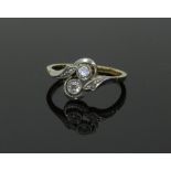 A two-stone diamond ring, in crossover type setting with a small diamond to each shoulder,