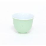 A Chinese celadon glazed cup with flared rim, incised blue highlighted mark, 8.