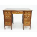 A mahogany kneehole desk fitted a surround of seven drawers on square taper legs,