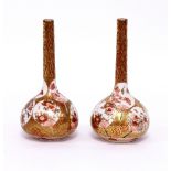 A pair of Japanese Imari vases in gilt and orange with slender necks and decorated circular fans,