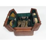 A leather dressing case containing silver topped and white metal topped brushes, glass bottles etc,