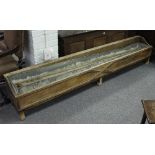A large oak feeding trough, with panelled front and zinc container,