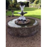 A cast iron two-tier fountain, the top with twin putto support,