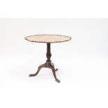 A late 18th Century mahogany table, the circular top on a turned column and tripod support, the