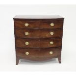 A Regency bowfront chest of drawers of two short and three long drawers with oval swing handles on