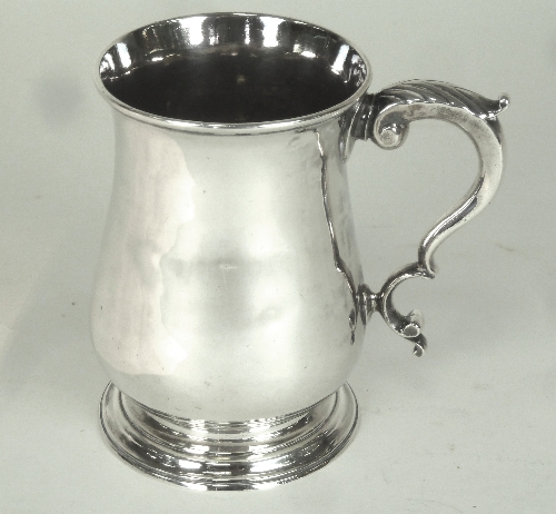 A George III silver mug, William & John Deane, London 1764, of baluster form with leaf capped scroll