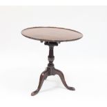 A George III mahogany tripod table with circular dished top and birdcage action on a turned column