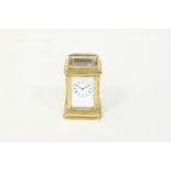 A miniature gilt brass carriage clock with rectangular enamel dial and eight-day movement and a