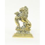 A 19th Century lion and shield brass door stop,