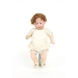 A German baby bisque doll with weighted eyes, open mouth, moveable limbs, in a cream cotton and lace