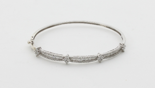 A diamond set hinged bangle, set with three rows of diamonds interspersed by four clusters of four - Image 2 of 2