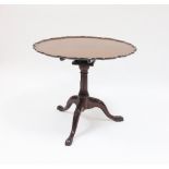 A George III mahogany tripod table with single plank pie crust top on bird cage action, on fluted