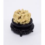 A Japanese carved ivory netsuke, Meiji period, modelled as a coiled dragon above a surround of