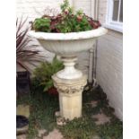 A cast iron circular vase etched lotus leaves on an octagonal stone column, 94cm diameter,