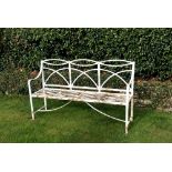 A Regency wrought iron garden seat with reeded interwoven back and slatted seat, the legs on bow