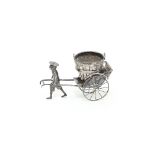 A Chinese white metal figure of a man pulling a rickshaw
 with a basket,