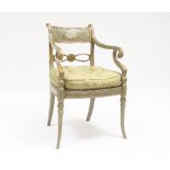 A Regency parcel gilt and green armchair, painted a cherub panel within leaf scrolls, with scroll