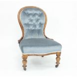 A Victorian nursing chair with blue velvet upholstery on turned baluster legs