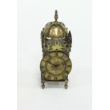 A brass lantern type clock Condition Report: The clock does not strike, the bell is decorative