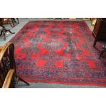 An Ushak carpet with green and blue geometric designs on a red ground 356cm x 276cm