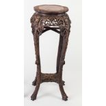 A Chinese hardwood jardiniere stand with wavy marble top on simulated bamboo carved legs,